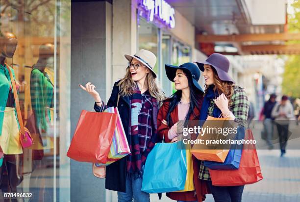 girlfriends are shopping and looking in the store window - shopaholic stock pictures, royalty-free photos & images