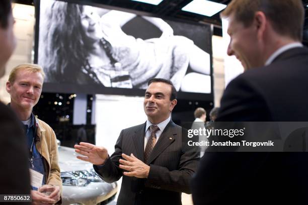 Carlos Ghosn, CEO of Nissan and Renault speaks with staff members at the Los Angeles auto show November 14, 2007 in Los Angeles, California.