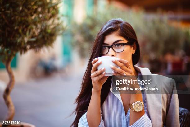 snygg ung kvinna med glasögon dricka kaffe på urban café - greek chef bildbanksfoton och bilder