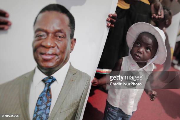Girl looks at the image of the new president Emmerson Mnangagwa during the ceremony officially sworn-in in Harare on November 24, 2017. Emmerson...