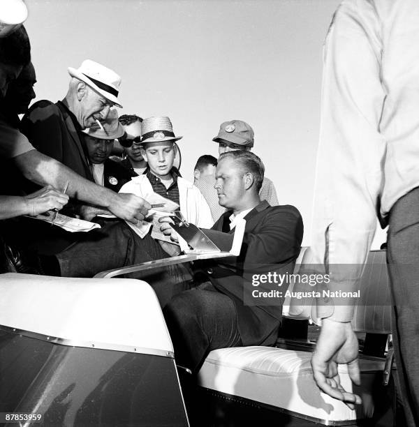 Masters Champion Jack Nicklaus signs autographs from the golf cart during the 1963 Masters Tournament at Augusta National Golf Club 0n April 7th,...