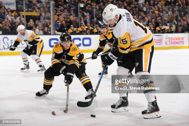 Riley Sheahan of the Pittsburgh Penguins handles the puck against Torey Krug of the Boston Bruins at the TD Garden on November 24, 2017 in Boston,...