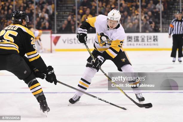 Olli Maatta of the Pittsburgh Penguins skates against Brandon Calro of the Boston Bruins at the TD Garden on November 24, 2017 in Boston,...