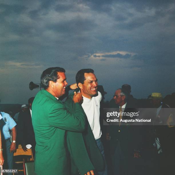 Gay Brewer helps Masters Champion Bob Goalby with his Green Jacket at the Presentation Ceremony during the 1968 Masters Tournament at Augusta...