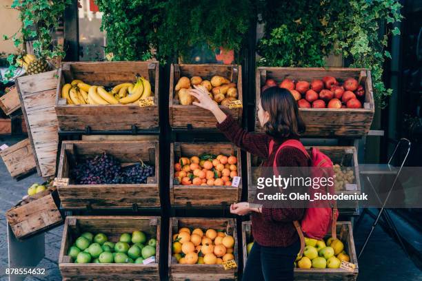 woman choosing fresh fruits on the street of florence - italian market stock pictures, royalty-free photos & images