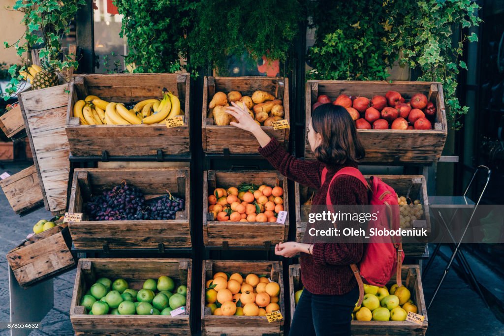 Woman choosing fresh fruits on the street of Florence