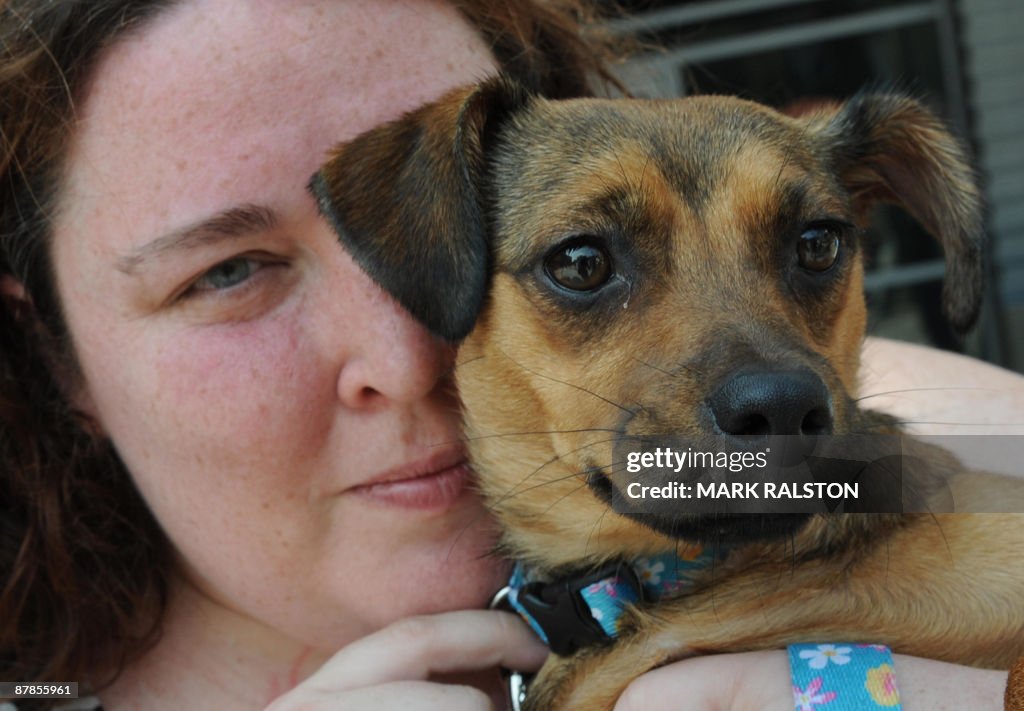 Hero Dog "Miley" is cuddled by owner Sta