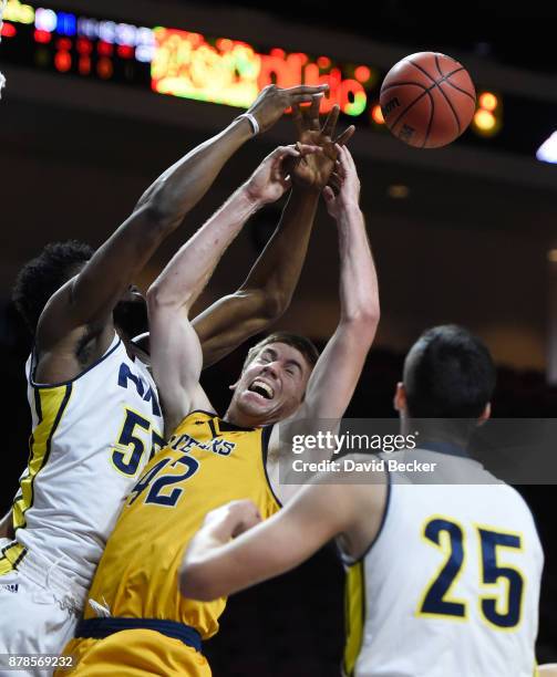 Tommy Rutherford of the UC Irvine Anteaters reaches for a rebound against Ruben Fuamba and Brooks Debisschop of the Northern Arizona Lumberjacks and...