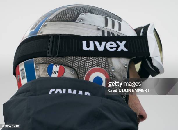 French ski racer Adrien Theaux wears a sticker on his helmet, in honor of his teammate David Poisson, during a downhill training run November 24,...