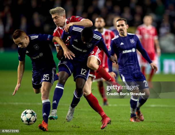 Robert Lewandowski of FC Bayern Muenchen is challenged by Adrien Trebel and Dennis Appiah of Anderlecht during the UEFA Champions League group B...