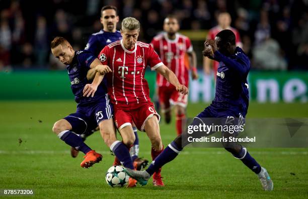 Robert Lewandowski of FC Bayern Muenchen is challenged by Adrien Trebel and Dennis Appiah of Anderlecht during the UEFA Champions League group B...