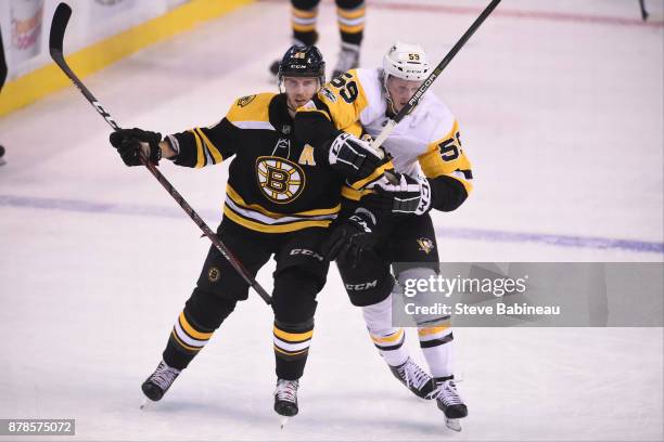 David Krejci of the Boston Bruins skates against Jake Guentzel of the Pittsburgh Penguins at the TD Garden on November 24, 2017 in Boston,...