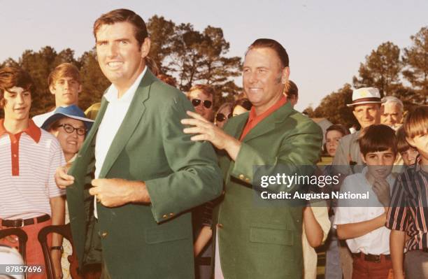 Billy Casper helps Masters Champion Charles Coody speaks with his Green Jacket at the Presentation Ceremony during the 1971 Masters Tournament at...