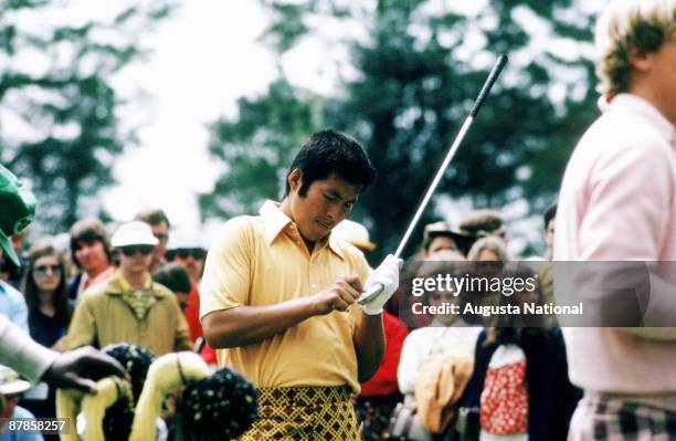 Masashi Ozaki cleans the grooves on his club face during the 1973 Masters Tournament at Augusta National Golf Club in April 1973 in Augusta, Georgia.