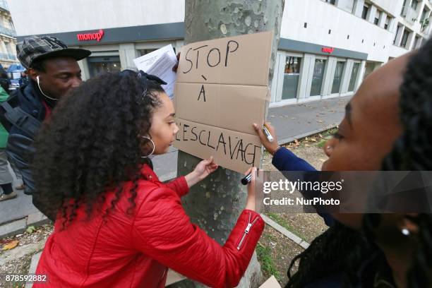 Woman writes a sign reading Stop to slavery during a demonstration against slavery in Libya on November 23 outside the Libyan embassy in the French...