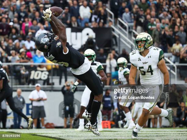 Dredrick Snelson of the UCF Knights catches a pass for a touchdown as Nico Sawtelle of the South Florida Bulls looks on in the first quarter at...