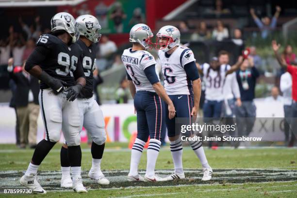 Punter Ryan Allen and Stephen Gostkowski of the New England Patriots celebrate a long field goal against of the Oakland Raiders at Estadio Azteca on...