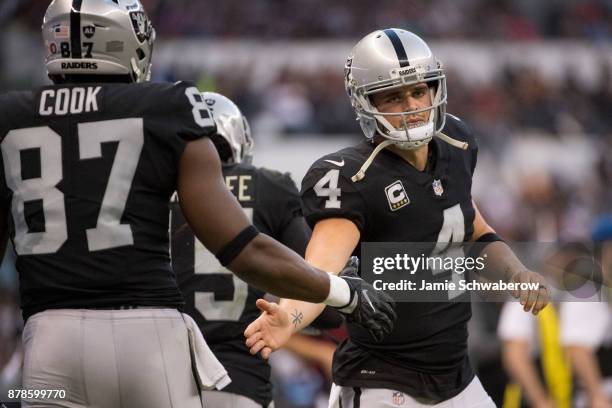 Quarterback Derek Carr of the Oakland Raiders gives high fives against the New England Patriots at Estadio Azteca on November 19, 2017 in Mexico...