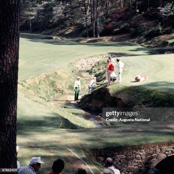 Masters Champion Gary Player studies the position of his ball in the water hazard of the 13th hole during the 1978 Masters Tournament at Augusta...