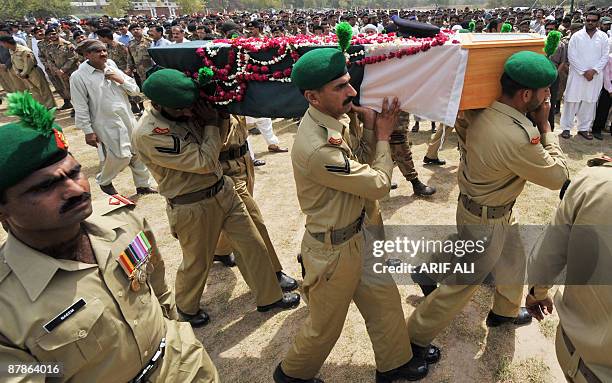 Pakistani troops carry the coffin of Army Major Abid Majeed Malik, who was killed in the ongoing operation against Taliban militants in the troubled...