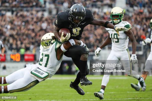 Adrian Killins Jr. #9 of the UCF Knights runs the ball for a touchdown in the first quarter as Naytron Culpepper of the South Florida Bulls defends...