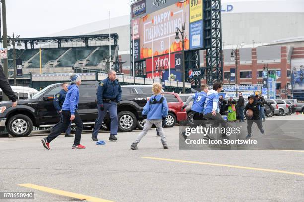 Boys play touch football in the parking lot next to Comerica Park and Ford Field with Michigan State Police prior to the Detroit Lions game versus...