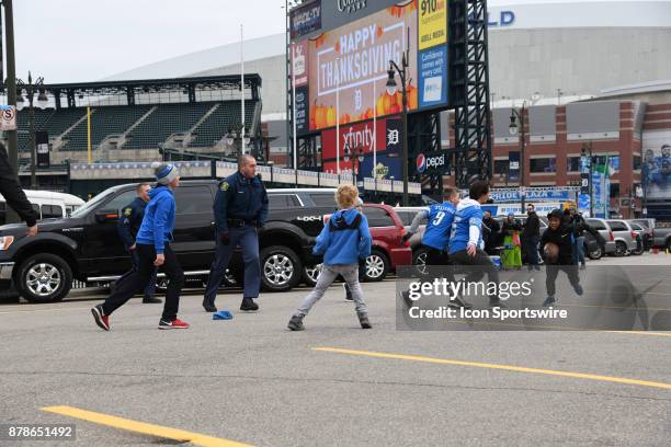 Boys play touch football in the parking lot next to Comerica Park and Ford Field with Michigan State Police prior to the Detroit Lions game versus...