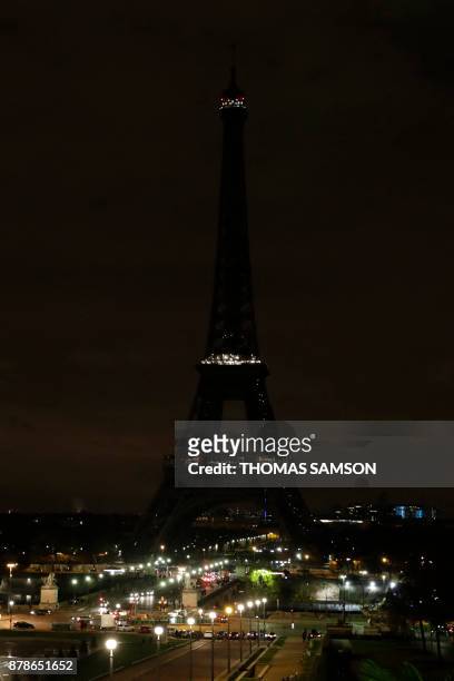 The lights of the Eiffel Tower in Paris are switched off on November 24, 2017 in tribute to the victims of the deadly attack on a mosque in Egypt's...