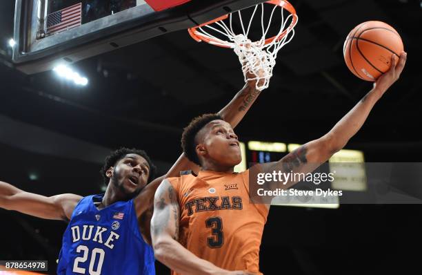 Jacob Young of the Texas Longhorns drives to the basket on Marques Bolden of the Duke Blue Devils during the first half of the game during the...