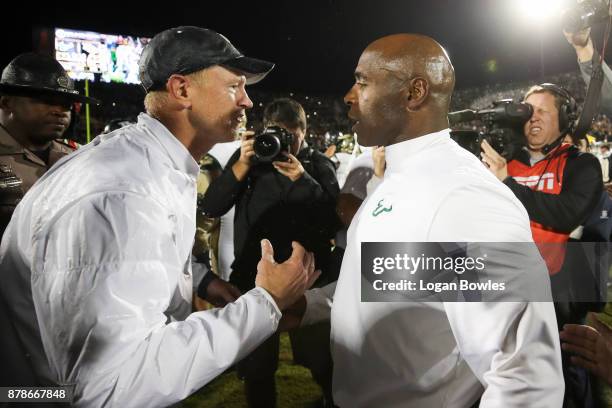 Head coach Scott Frost of the UCF Knights and head coach Charlie Strong of the South Florida Bulls shake hands after a game at Spectrum Stadium on...