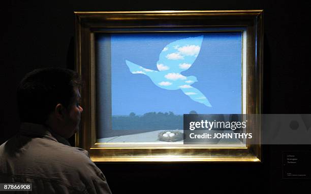 Visitor looks at "The Returns 1940 " a painting by the Belgian artiste Rene Magritte displayed at the press opening of the new Magritte museum in...