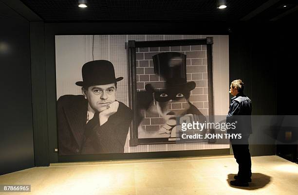 Visitors looks at a painting of the Belgian artist Rene Magritte at the press opening of the new Margitte museum in Brussels on May 20, 2009. The...
