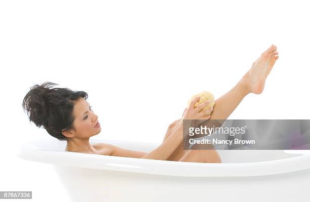 young asian woman taking a bath - long legs women stock-fotos und bilder