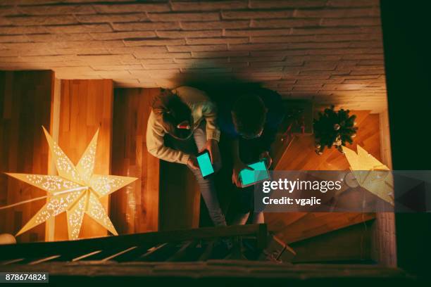 broer en zus plezier hebben op kerstavond - christmas tree stockfoto's en -beelden