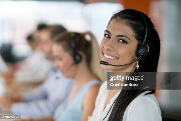 happy latin american woman working at a call center - estate agent stock pictures, royalty-free photos & images