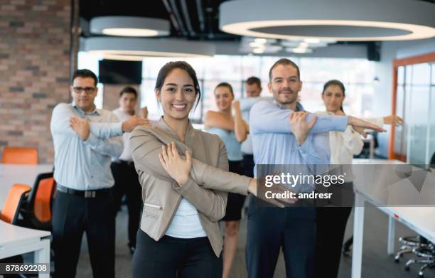 uomini d'affari che si allungano in ufficio - sport office foto e immagini stock