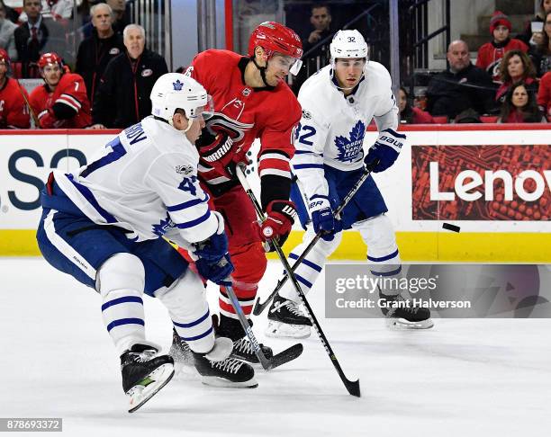 Marcus Kruger of the Carolina Hurricanes and Leo Komarov of the Toronto Maple Leafs battle for the puck during their game at PNC Arena on November...