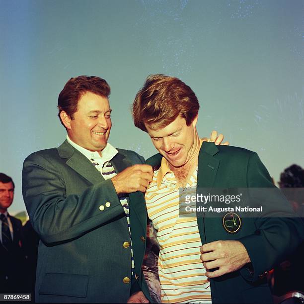 Tom Watson receives his first green jacket from Raymond Floyd after the 1977 Masters Tournament at Augusta National Golf Club in April 1977 in...