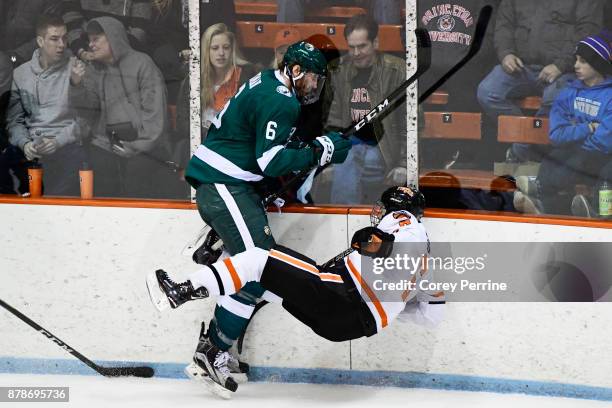 Jay Dickman of the Bemidji State Beavers checks Matt Nelson of the Princeton Tigers onto the ice during the second period at Hobey Baker Rink on...