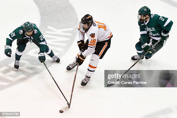 Gerry Fitzgerald of the Bemidji State Beavers Eric Robinson of the Princeton Tigers and Dan Billett of the Bemidji State Beavers vie for the puck...