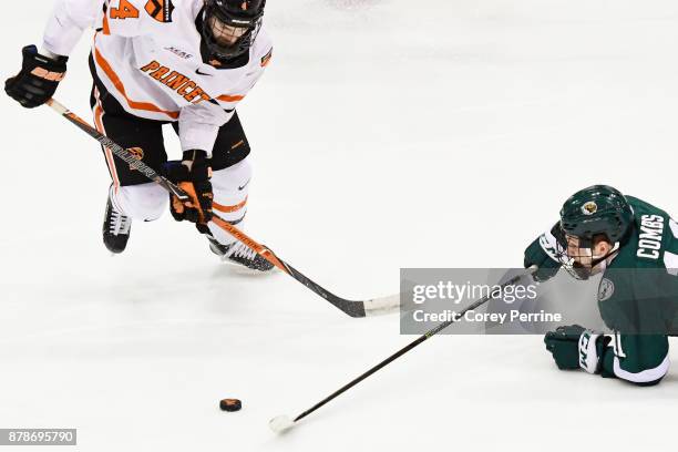 Charlie Combs of the Bemidji State Beavers loses his footing and the puck to Josh Teves of the Princeton Tigers during the second period at Hobey...