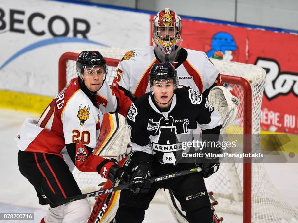 Xavier Bouchard of the Baie-Comeau Drakkar and Alexandre Alain of the Blainville-Boisbriand Armada battle for position in front of goaltender Antoine...