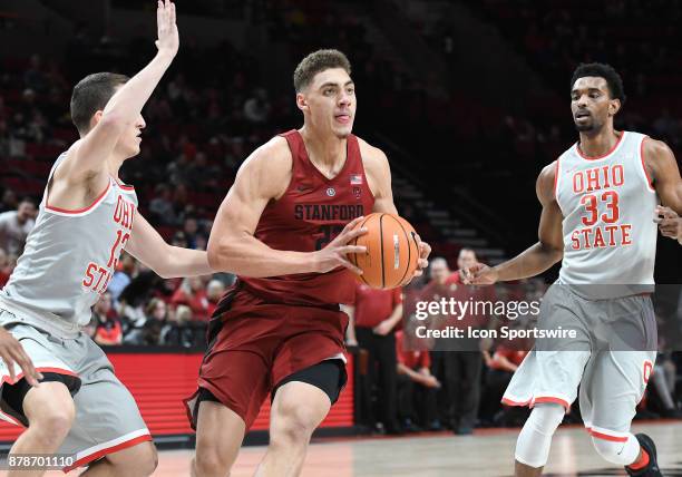 Stanford University forward Reid Travis looks to pass against Ohio State University guard Andrew Dakich and Ohio State University forward Keita...