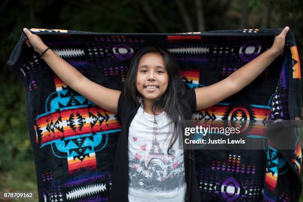 preteen yurok tribal girl standing, wears modern teeshirt holding tribal blanket - indio california fotografías e imágenes de stock