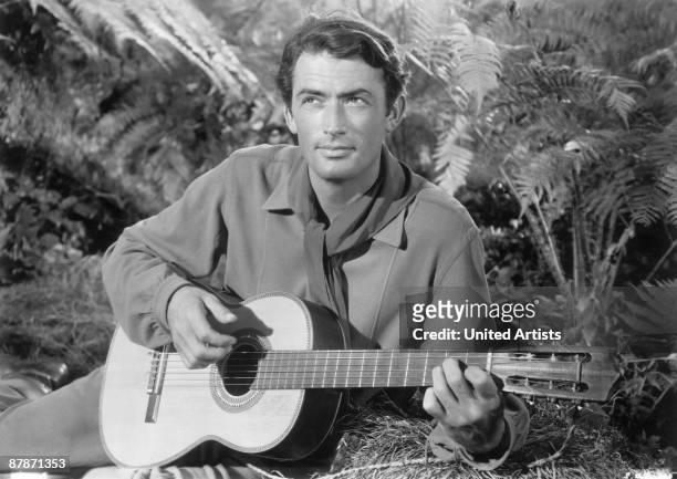 American actor Gregory Peck strums a guitar in a still from director King Vidor's film, 'Duel in the Sun,' 1946.
