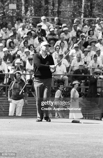 Billy Casper watches the flight of his ball before a large gallery during the 1980 Masters Tournament at Augusta National Golf Club on April 1980 in...