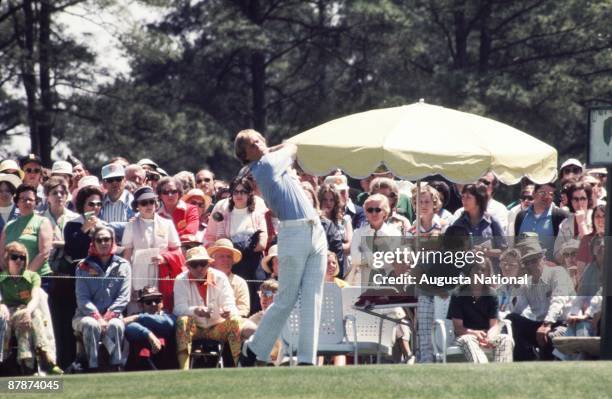 Johnny Miller watches the flight of his ball in front of a large gallery during the 1975 Masters Tournament at Augusta National Golf Club in April...