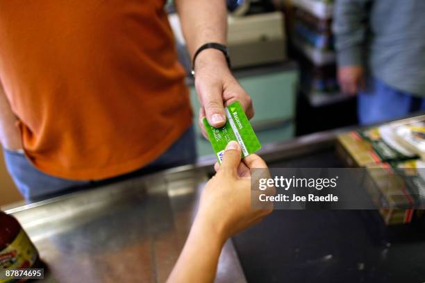 Yera Dominguez receives a credit card from a customer for payment at Lorenzo's Italian Market on May 20, 2009 in Miami, Florida. Members of Congress...