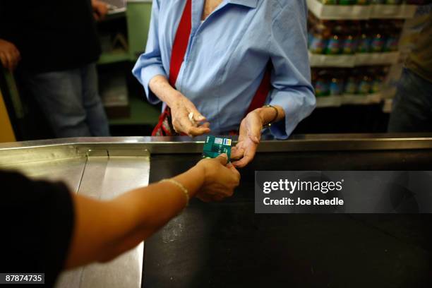 Yera Dominguez receives a credit card from a customer for payment at Lorenzo's Italian Market on May 20, 2009 in Miami, Florida. Members of Congress...
