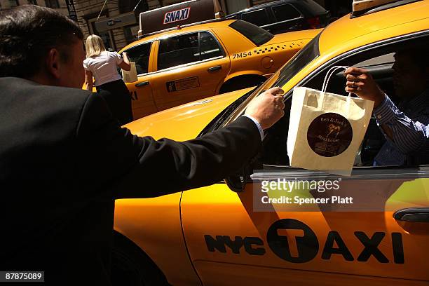 Ben Sinanaj hands out a free bagged lunch to a taxi driver, compliments of Ben & Jacks Steakhouse on May 20, 2009 in New York City. The restaurant...